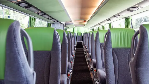Leere Sitze im Bus, bereit für die Fahrt von Setúbal nach Lissabon. Grüne und graue Polster, Blick in den Gang.