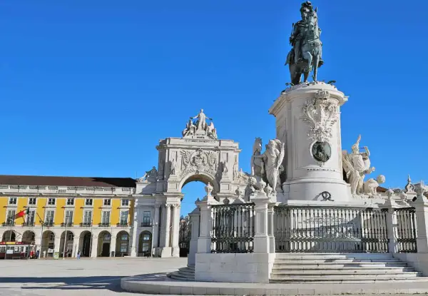 Reiterdenkmal und Triumphbogen am Praça do Comércio in **Baixa Lissabon** unter strahlend blauem Himmel.