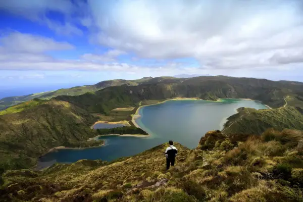 Ein Mann blickt auf eine atemberaubende Kraterlandschaft mit mehreren Seen. Die Frage, ob Madeira zu den Azoren gehört, wird hier durch die Schönheit der Natur beantwortet.