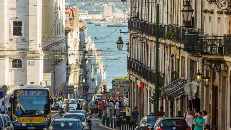 Ein belebter Tag in Lissabon, wo die portugiesischen Einwohner die engen Gassen mit ihren historischen Gebäuden und dem Blick auf das Wasser beleben.